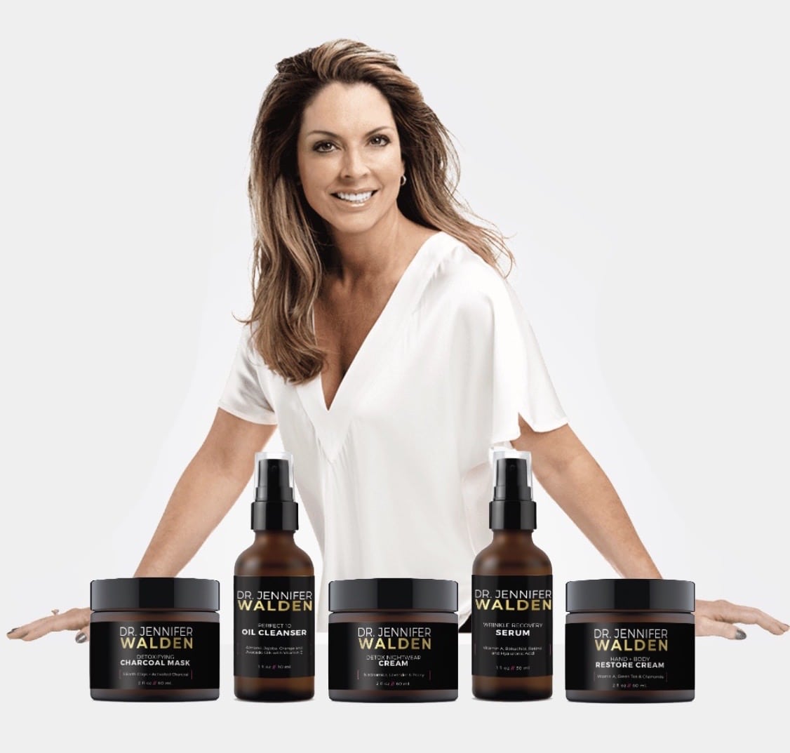 Dr. Jennifer Walden standing behind various acne treatment products